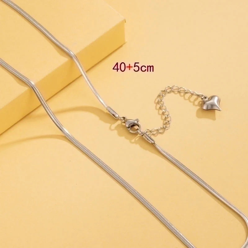 Silver chain necklace with clasp on a yellow background