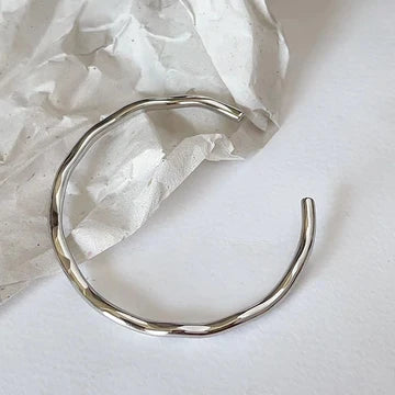 Silver hoop earring on a light background